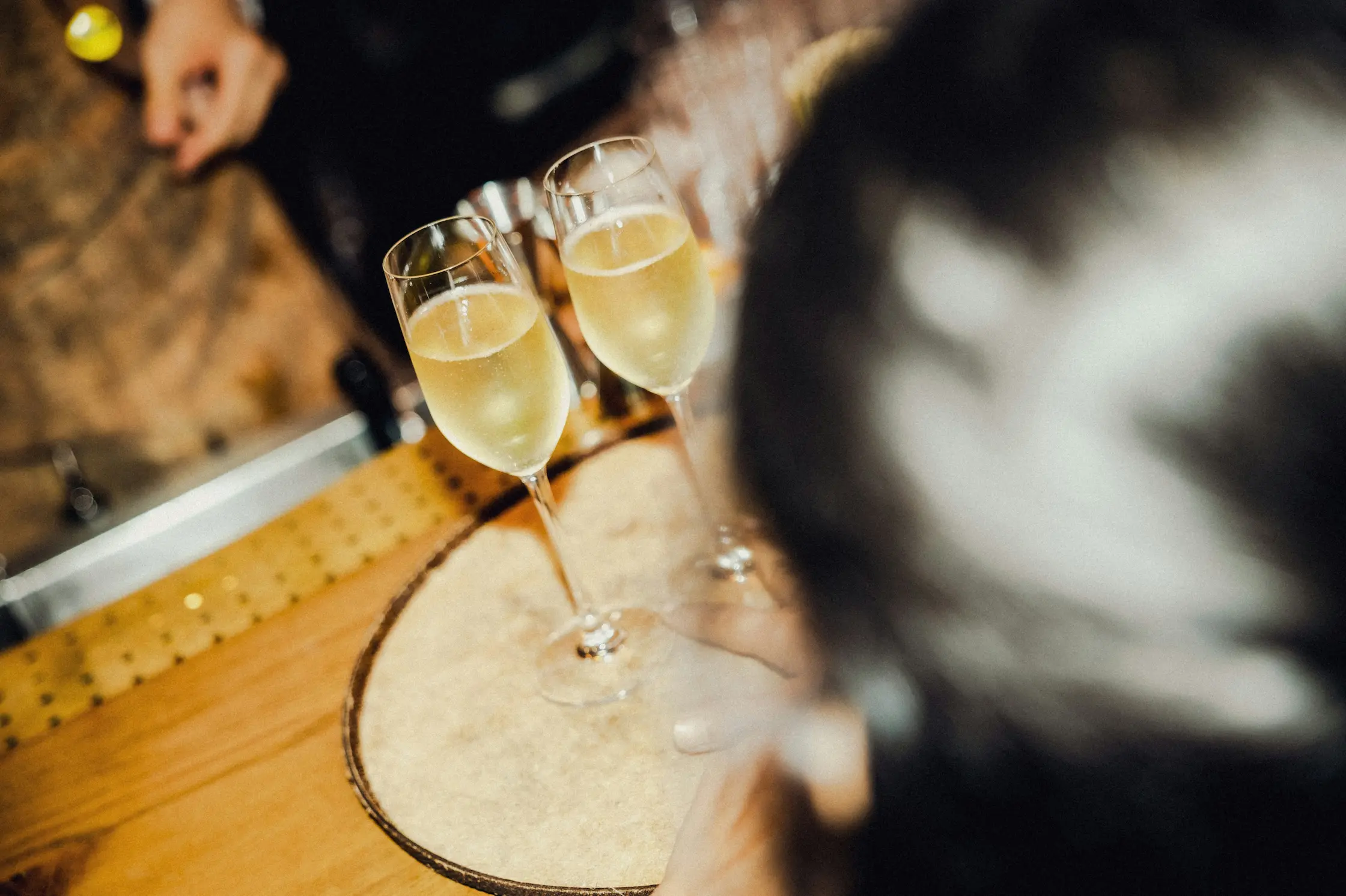 Deux flûtes de champagne posées sur un comptoir en bois